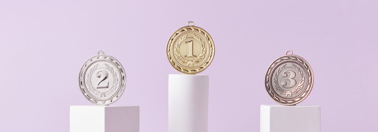 Medals on a podium against a soft pastel background, ideal for awards themes.